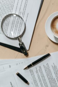 Top view of documents with a magnifying glass and pen, ideal for business or legal themes.