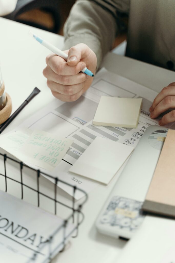 pexels-photo-7429465-7429465 Adult working on a project with sticky notes and calendar at a desk.