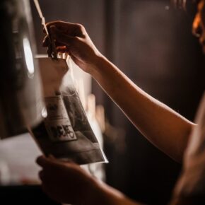Person developing film in a darkroom, highlighting traditional photography techniques.