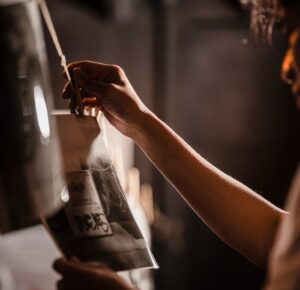 Person developing film in a darkroom, highlighting traditional photography techniques.
